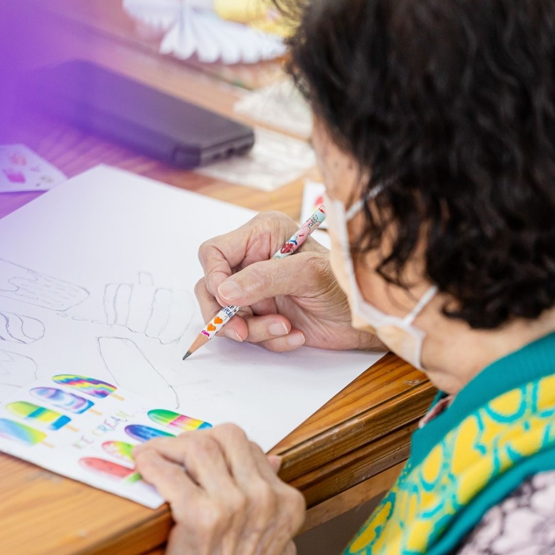 長者奶奶在活動中於白紙上繪製彩色圖案