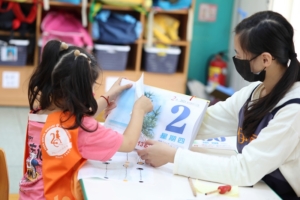 教保員正在陪同服務對象認識日曆的使用方式